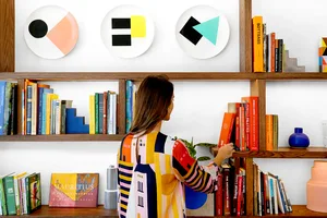 A modern bookshelf with colorful objects and books.