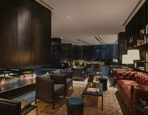 Interior design of a modern industrial hotel lobby featuring concrete and leather furniture.