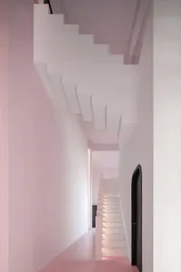 A modern interior design featuring a light pink staircase with white walls and a ceiling.
