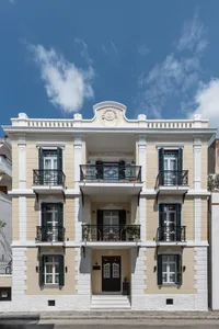 A modern residential building with concrete walls and white stucco finish.