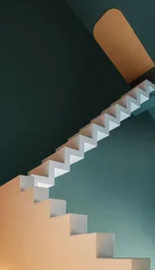 Staircase with white painted steps against a dark green painted wall