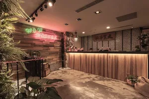 Modern hostel lobby featuring industrial design elements with wood and concrete finishes and live plants