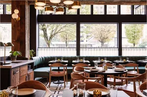 A modern, industrial-styled restaurant interior with wood, leather, and metal materials.