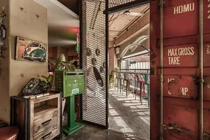 Industrial-style restaurant interior featuring a metal shipping container and rustic elements.