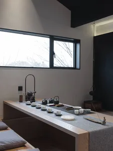 Minimalist interior design featuring a tea room with wooden elements and white decor.