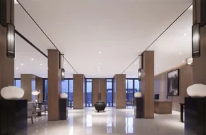 Modern hotel lobby with sleek, wooden columns, minimalist decor, and floor-to-ceiling glass windows.