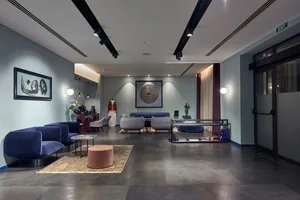 A modern lobby with concrete flooring, glass walls, and minimalist furniture.