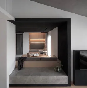 A modern, minimalist living room with concrete flooring, wooden furniture, and a sleek, contemporary design.
