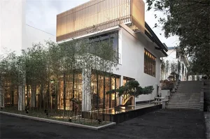 A modern residential exterior with concrete finish and a lush green garden.