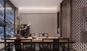 Modern tea room featuring wooden furniture and decoration, with a vase of greenery and tea set on a table.