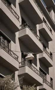 Concrete building with balconies and streetlight hanging from wire