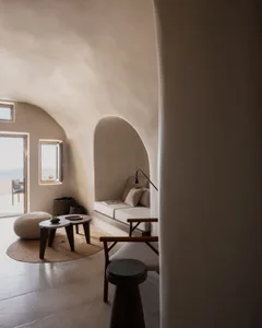 A minimalist room with sandstone walls and a comfortable seating area.