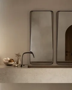 Angular modern bathroom with concrete sink and sink faucet.