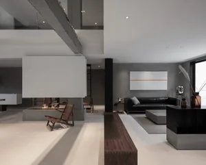 A modern industrial living room featuring a concrete floor, steel beams, a fireplace, and minimalist furniture.