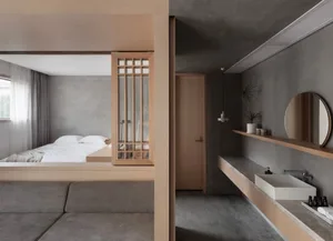Modern minimalist bedroom with concrete finishes, floating shelves, and a floating bed platform.