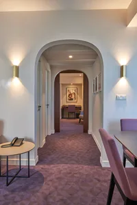 Modern hotel suite featuring a purple carpet and archways