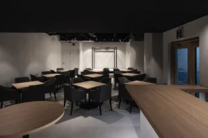 A cozy restaurant interior with wooden tables and black chairs