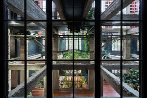An industrial-style interior space with concrete architecture and greenery.