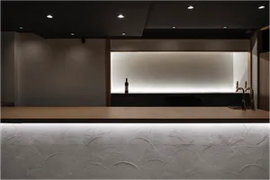 A sleek, modern bar counter featuring minimalist design elements and warm lighting in an airport setting.