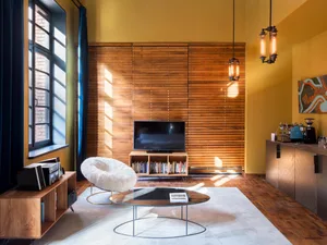 A modern industrial living room with wooden accents and a large window.