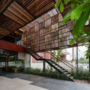 A modern industrial-style lobby entrance with wooden slats and a black staircase.