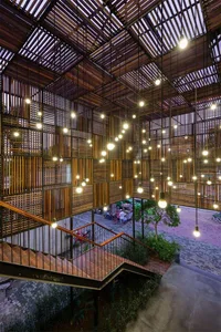 A modern lobby with a brick ceiling featuring exposed wooden beams and pendant lights.