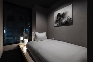 A minimalist bedroom with a textured wall material.