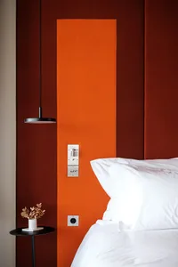 A minimalist bedroom featuring a headboard with fabric upholstery and a sleek, modern design.