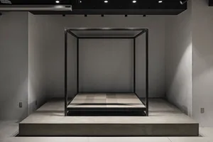 A minimalist metal frame structure on a concrete platform