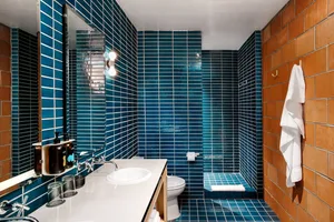 Modern bathroom featuring blue ceramic tiles and white fixtures.