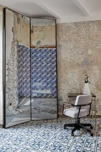 Industrial-themed office interior with blue and white tiles on the floor and walls, featuring a modern office chair and desk.