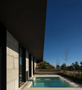 A modern residential exterior featuring concrete walls and a sleek, minimalist design.