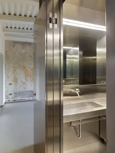 A modern, minimalist bathroom featuring stainless steel surfaces and fixtures.