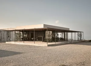 Modern minimalist residential exterior featuring exposed concrete structure and minimalist design elements.