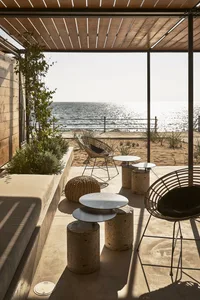 Minimalist patio featuring concrete furniture and a view of the ocean.
