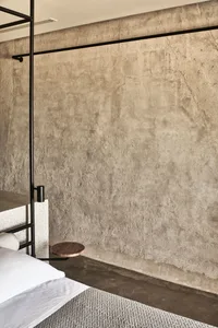 Minimalist modern bedroom featuring concrete walls and minimalist furniture.