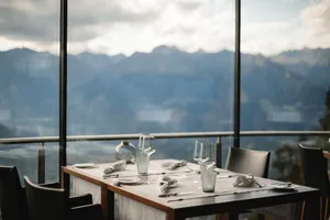 Modern restaurant tablescape featuring glassware and a scenic view through a large window.
