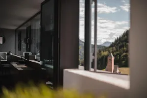 Modern indoor space with glass window overlooking scenic mountain view.