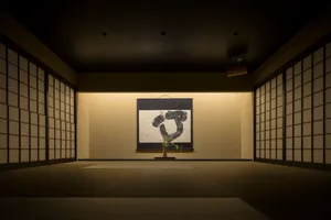 A minimalist interior features a framed piece of art displayed on a wall.