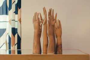 A collection of wooden hand sculptures arranged in a modern interior setting.
