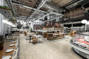 Industrial-themed restaurant with concrete floors and concrete pillars