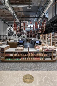 Modern retail food market with a sleek, minimalist design featuring a wooden counter adorned with various food products and h