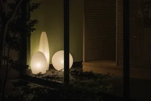 Three spherical lanterns made of paper, illuminating a living room.