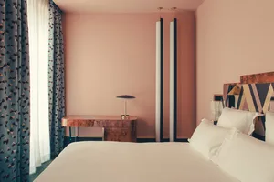 Bedroom with minimalist design, featuring a wooden bed frame and white bedding.