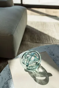 Glass sculpture on a coffee table in a minimalist interior design setting