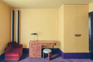 A minimalist living room with wooden furniture and fabric upholstery.