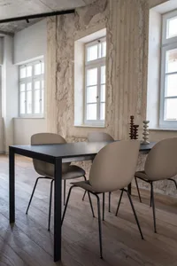 A modern dining room featuring a metallic table with four chairs and decorative candle holders on the table.