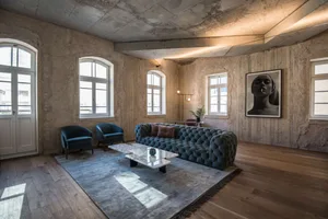 Contemporary living room with wood flooring, concrete walls, and modern furniture.