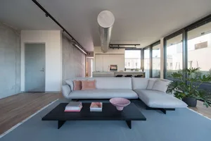 A modern living room with concrete, glass, and wooden materials.