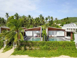 Modern residential villa with a private swimming pool and a combination of concrete and wood architectural elements.